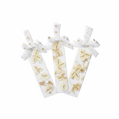 The J.M Press white bookmarks with pressed beige flowers and gold heart ribbon.